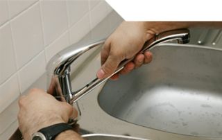 Plombier réparant un robinet