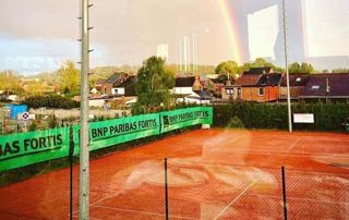 terrain de tennis avec un arc-en-ciel en arrière plan