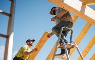 deux couvreurs construisent une charpente